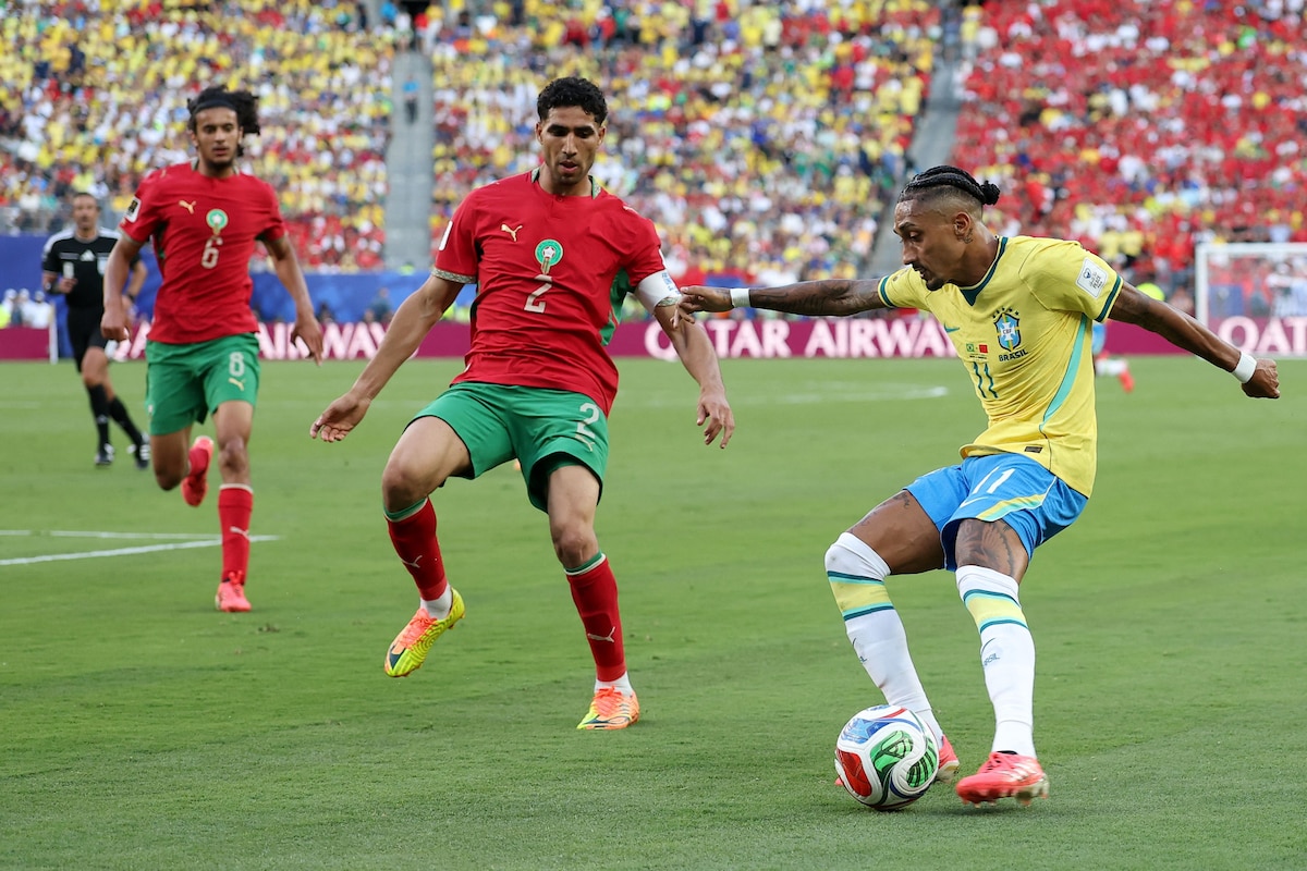 EAST RUTHERFORD, NEW JERSEY - JUNE 13: Raphinha #11 of Brazil crosses the ball against Achraf Hakimi #2 of Morocco during the FIFA World Cup 2026 Group C match between Brazil and Morocco at New York New Jersey Stadium on June 13, 2026 in East Rutherford, New Jersey. Darrian Traynor/Getty Images/AFP (Photo by Darrian Traynor / GETTY IMAGES NORTH AMERICA / Getty Images via AFP)
